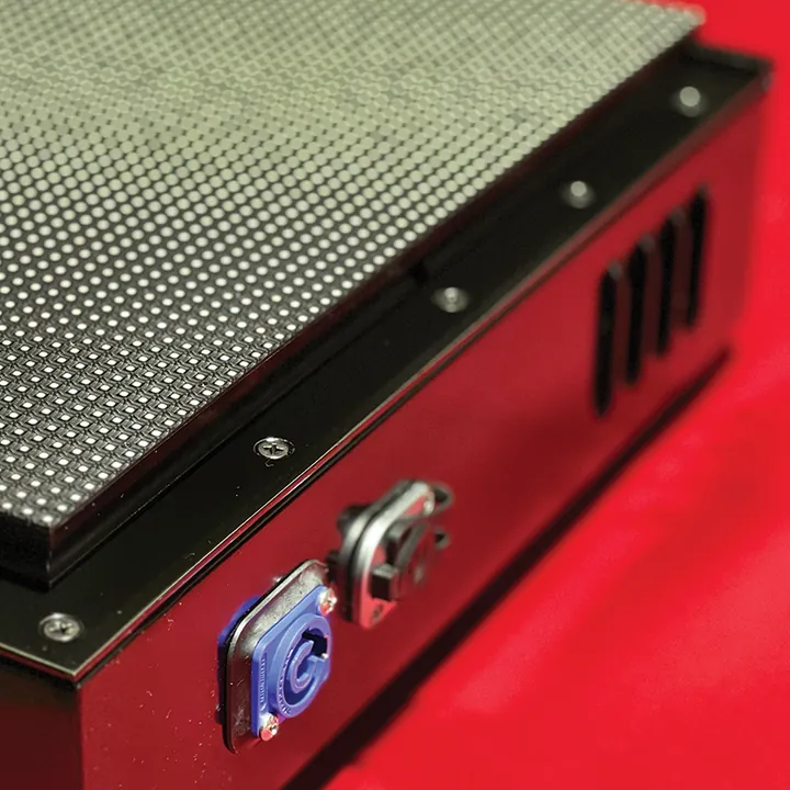Close-up of the blue twist-lock power connector, the Ethernet port and the vents