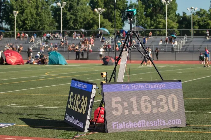 Display boards showing CA State Champs and 5:16:30 beside the track
