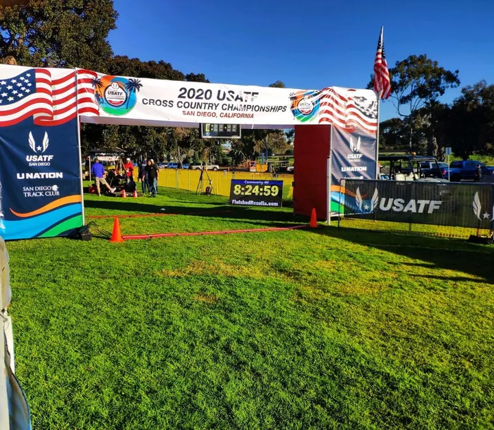 A display board showing Community 4K and 8:24:59 at the 2020 USATF Cross Country Championships finish